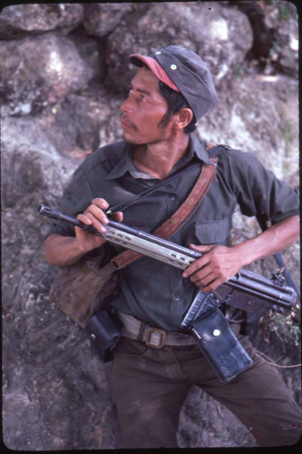 Guerrilla man standing in front of rocks, La Palma, 1983