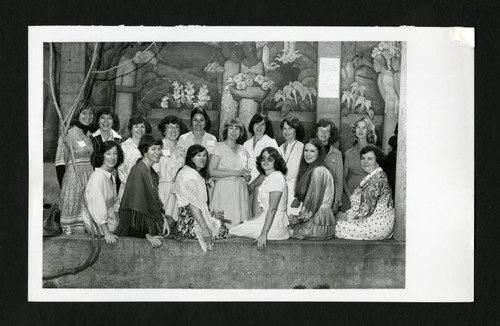 Alumnae of Scripps class of 1968 sitting together by a mural in Margaret Fowler Garden, Scripps College