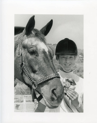 Show participant poses with horse and ribbon, 1990
