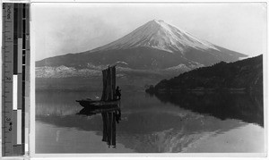 Man standing in a boat on a lake near Mt. Fuji, Japan, ca. 1920-1940