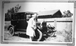 Harriet Crystal Elvy standing next to the Elvy car, about 1930