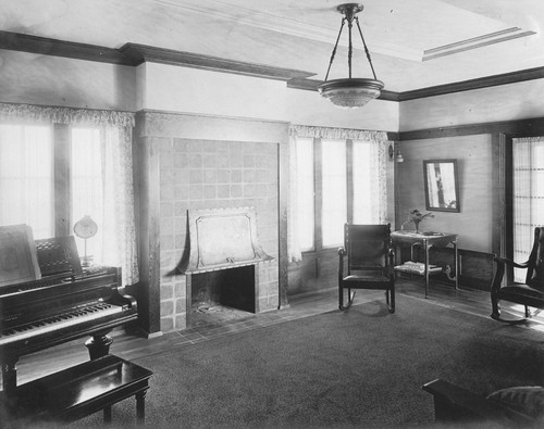 View of a living room with a fireplace, piano, and furniture