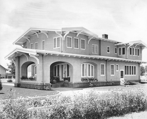 View of the back of a two-story house with a cellar and porte cochere