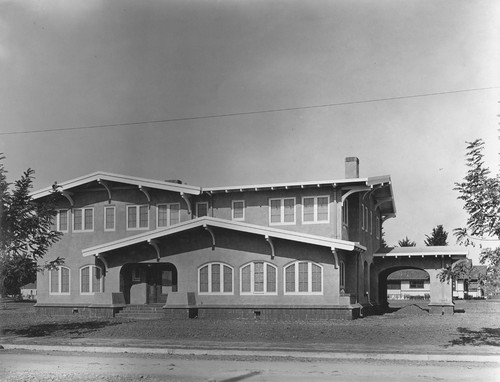 Front view of a two-story house with porte cochere