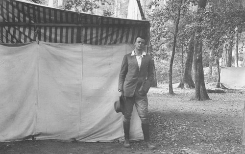 Andrew P. HIll, Jr. standing next to a tent in the forest