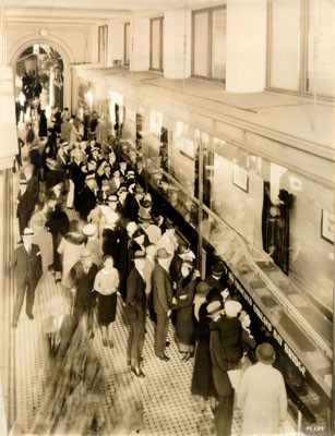[Crowd of people looking at a model of the San Francisco-Oakland Bay Bridge on exhibit in The Emporium department store on Market Street]