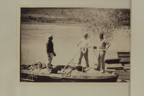 The crew of the motorboat "Hudson" before the start from Lees Ferry. Dock Marston; Joe Desloge; Guy Forcier. The "Esmeralda" is at the right