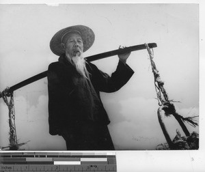 A man with a carrying pole at Fushun, China, 1937