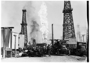 Workers examining the wreckage during an oil fire at an unidentified oil field
