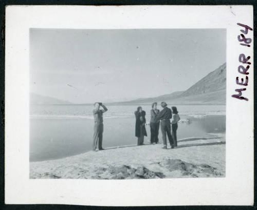 Photograph of L. Josephine Hawes and Theo Chamberlain in front of standing water at Bad Water in Death Valley