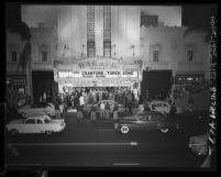 Automobiles passing by crowds outside Warner Bros. Theater for the "Torch Song" movie premiere in Los Angeles, Calif., 1953