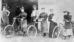 Four women and two men standing in front of a bicycle shop in Monrovia, 1887