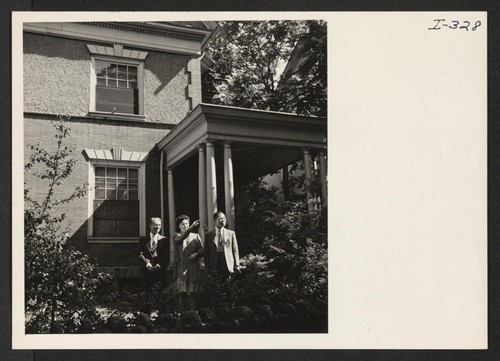 In front of their home on a tree-lined street in Philadelphia, Pennsylvania, Mr. and Mrs. Eishichiro George Koiwai, Issei formerly