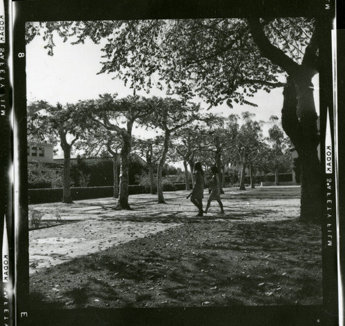Two Scripps students walking on a path leading to Mallott Commons, Scripps College