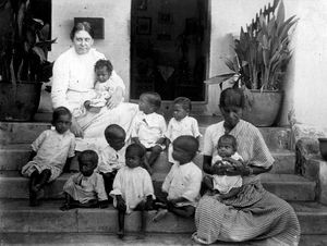 Missionary Miss Helga Ramlau (teacher, sent to India 1905) with orphans on the steps to the orp