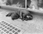 [Woman sleeping on sidewalk]