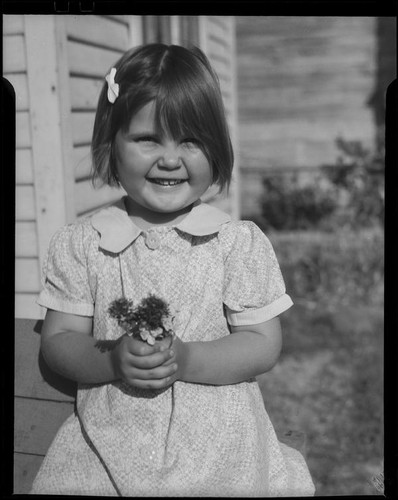 Girl holding flowers, Los Angeles, circa 1935