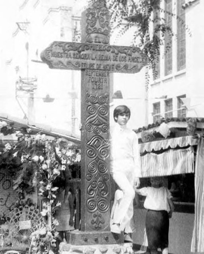 Photograph of a little boy standing by the cross on Flower and Camera Day
