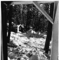 A staffer at Camp Sacramento is seen here shoveling snow from a cabin entrance. There is still snow on the ground in mid June