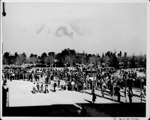 A crowd of people converges at a north entrance to the Coliseum in Los Angeles' Exposition Park