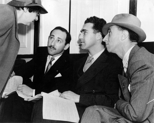 [Harry Bridges and his battery of defense attorneys consult on the day's battle ahead of them as their boat takes them to Angel Island for deportation hearing]