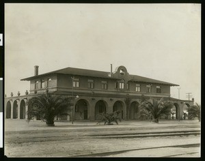 Exterior view of Merced's Harvey House next to railroad tracks, ca.1910