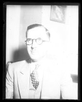 Portrait of man in suit with polka-dot tie and glasses