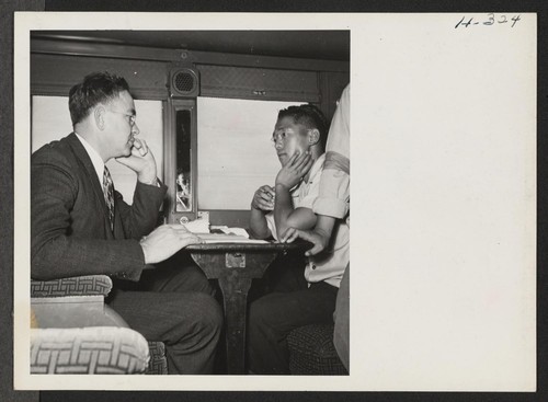 Roscoe Bell, W.R.A. representative on trip 15, Topaz to Tule Lake, checks with the car captains as to the comfort and well being of passengers in their respective cars. Photographer: Mace, Charles E
