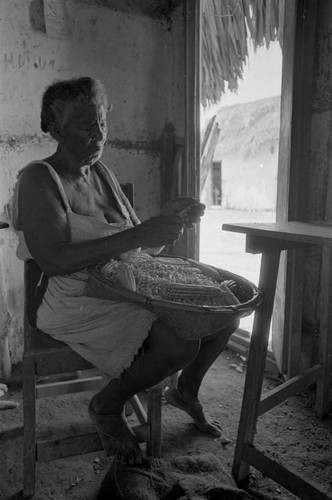 Woman removing corn from the cob, San Basilio de Palenque, 1976
