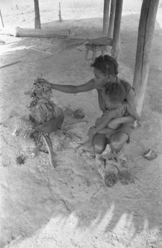 Young woman and infant by the fire, San Basilio de Palenque, 1977