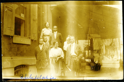 Group of men and women standing next to building