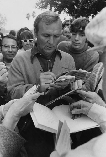 Arnie signs autographs