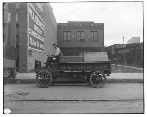A man driving Electric Truck #32, showing the Otis Elevator Company and the W.J. Wilson Co