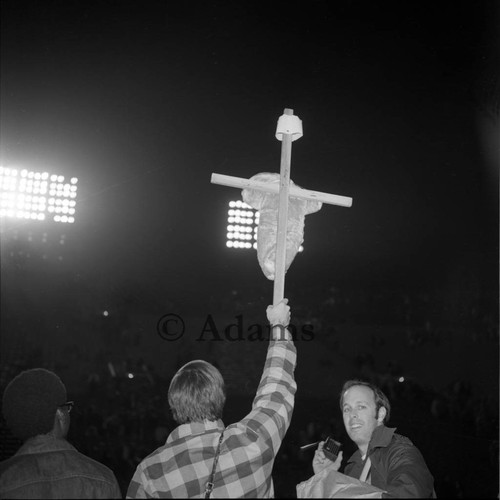 Man holds cross, Los Angeles, 1972