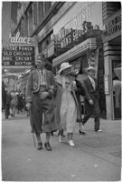 Nile Shrine member folding flyers on the street, Los Angeles, 1938