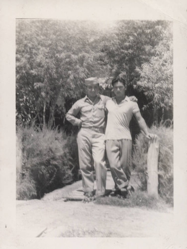 Mitsuru Yagura and young man standing on wooden walkway at Poston incarceration camp