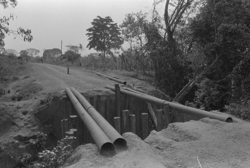 Water pipes passing over a ditch, San Basilio de Palenque, ca. 1978