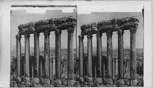The six high columns of the Pen Style of the Great Temple seen from afar by tourists. Baalbek, Syria