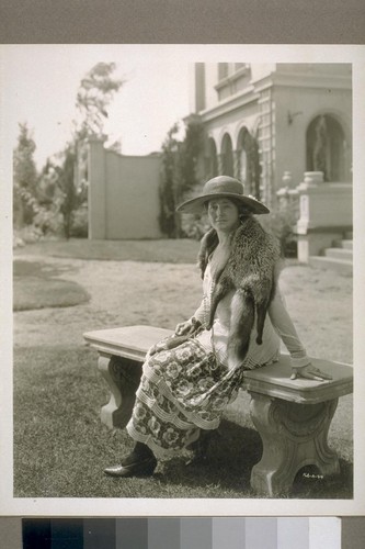 [Kathleen Norris sitting on a garden bench.]