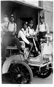 Four firemen of the all-black Engine Company No. 30 riding on a fire engine