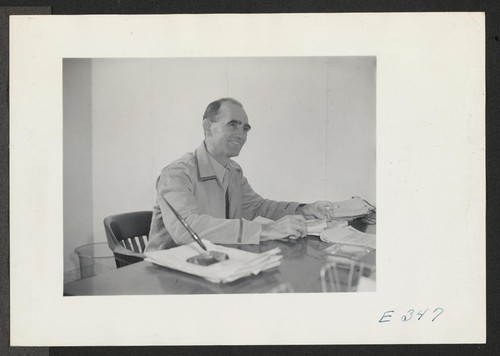 Ray D. Johnston, the Project Director at this center, seated at his desk in the Administrative Office. Photographer: Parker, Tom McGehee, Arkansas