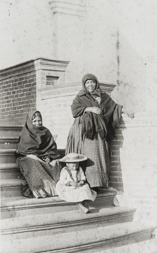 Ventureño Chumash women, Apolonia Guzman (left) and Petra Pico (right). The child seated on the steps is Petra's great granddaughter, Soraida García : ca. 1888