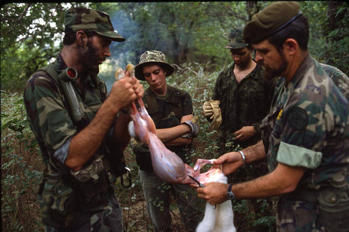 Harry Claflin and survival school students skin a rabbit, Liberal, 1982