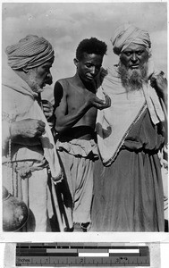 Three men standing outside together, Africa, October 3, 1939
