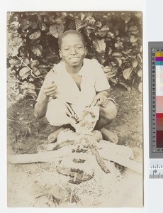 Young boy cooking outside, Malawi, ca.1910
