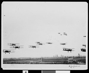 Military aircraft flying over the United Air Terminal in Burbank during the dedication of the airport, May 1930