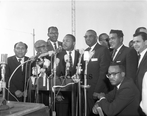 Dr. Martin Luther King, Jr. standing with others during the Freedom Rally at Wrigley Field, Los Angeles, 1963