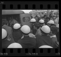 Protesters pushed into police patrol wagon after being arrested for demonstrating at Century Plaza during President Johnson's visit. B. 1967