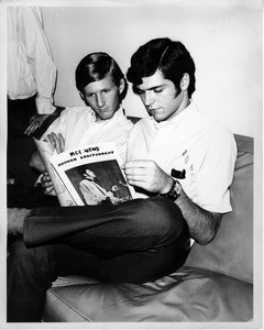 Two gay men read the MCC News