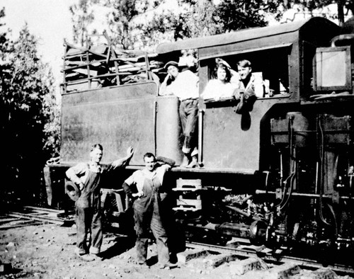 Unidentified people standing on steam locomotive in Lyonsville